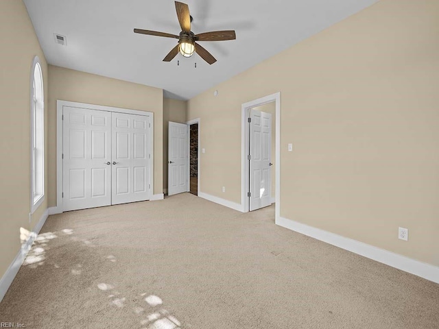 unfurnished bedroom with multiple windows, light colored carpet, visible vents, and baseboards