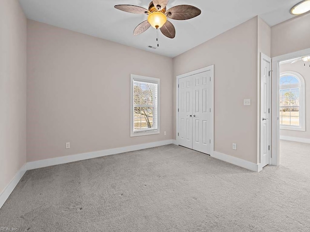 unfurnished bedroom with baseboards, a closet, visible vents, and light colored carpet