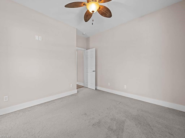 spare room with ceiling fan, baseboards, and light colored carpet