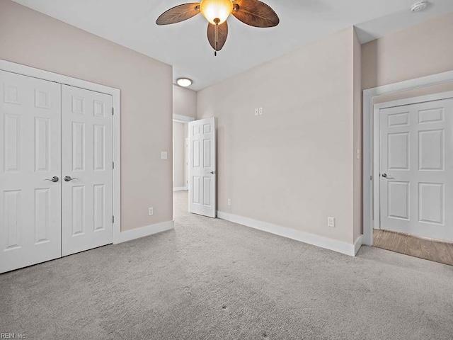 unfurnished bedroom featuring a closet, light colored carpet, and baseboards