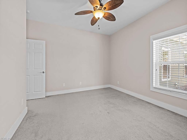 unfurnished room featuring light carpet, baseboards, and a ceiling fan