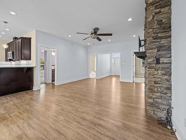 unfurnished living room with baseboards, a ceiling fan, wood finished floors, and recessed lighting