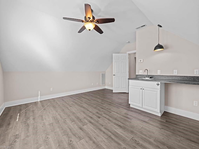 bonus room with dark wood-style floors, lofted ceiling, visible vents, and a sink