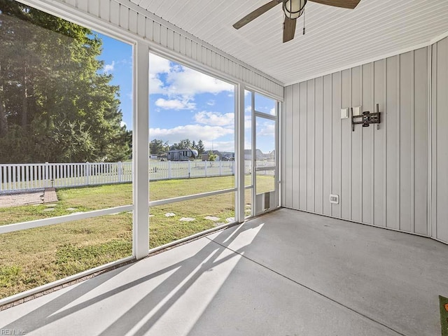 unfurnished sunroom featuring ceiling fan