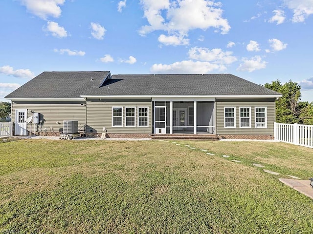 rear view of house featuring a yard, a fenced backyard, a sunroom, and central air condition unit