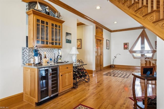 9954 Bonniville Rd, Hayes, VA 23072 - bar featuring beverage cooler, a sink, decorative backsplash, light wood finished floors, and indoor wet bar
