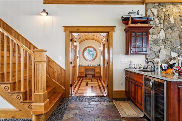 9954 Bonniville Rd, Hayes, VA 23072 - bar featuring stone tile flooring, stairway, a sink, wet bar, and beverage cooler