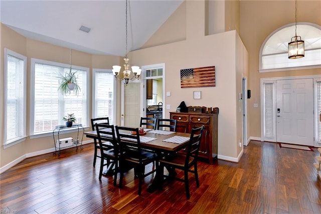 dining space with high vaulted ceiling, dark wood-style flooring, visible vents, and baseboards