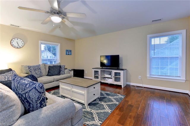 living area with a ceiling fan, dark wood-style flooring, visible vents, and baseboards