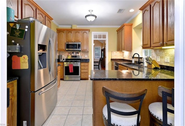 kitchen with light tile patterned floors, visible vents, appliances with stainless steel finishes, a sink, and a peninsula