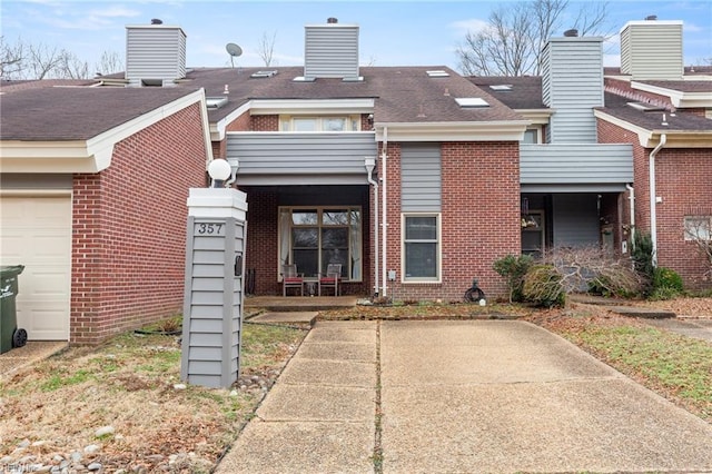 view of front facade featuring brick siding and roof with shingles