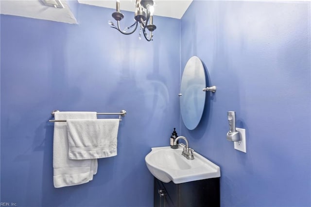 bathroom featuring a sink and an inviting chandelier