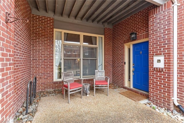 entrance to property featuring brick siding