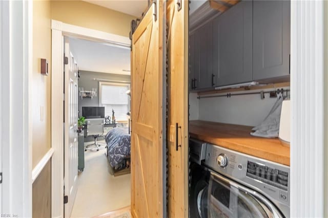 clothes washing area with washer / clothes dryer and cabinet space