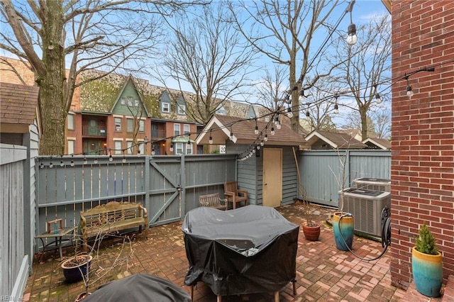 view of patio featuring a residential view, a fenced backyard, a gate, and central air condition unit