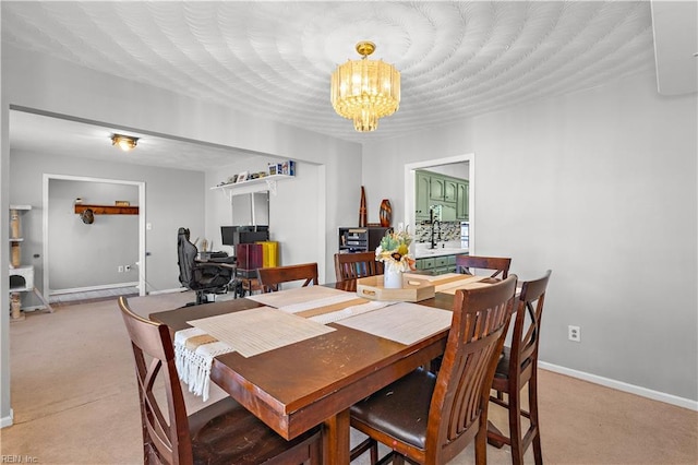 dining room with light colored carpet, a notable chandelier, and baseboards