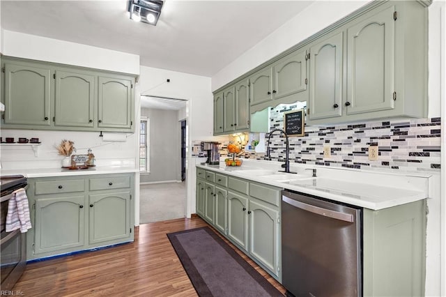 kitchen featuring a sink, stainless steel appliances, green cabinets, and light countertops