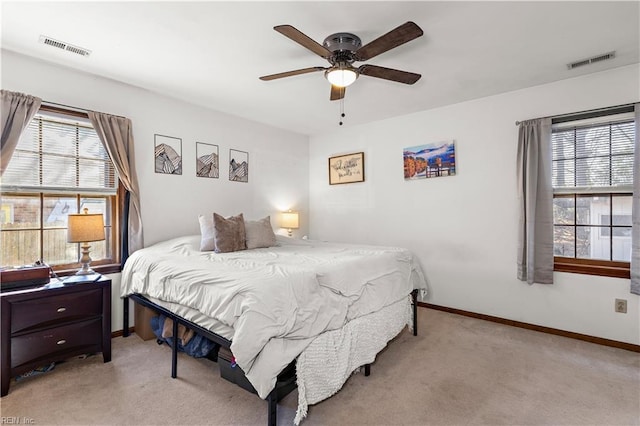 bedroom featuring baseboards, visible vents, and light colored carpet