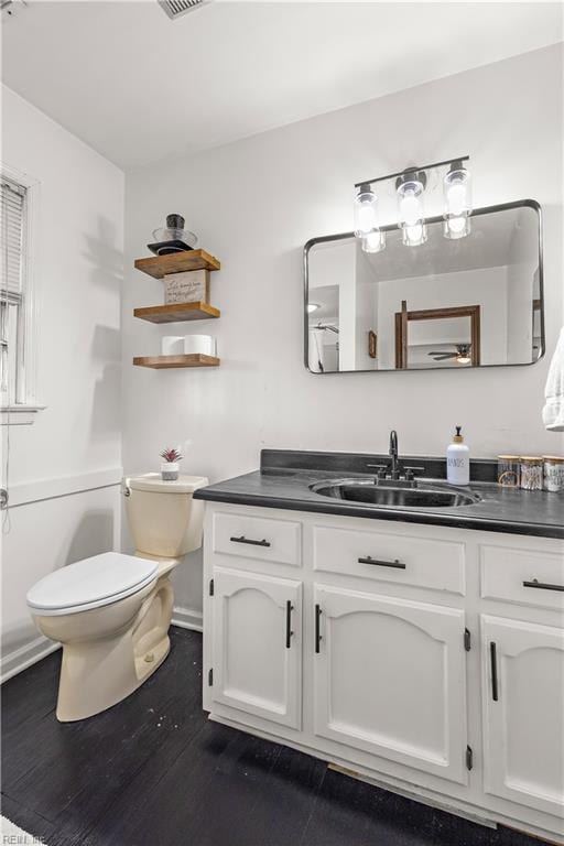 bathroom featuring visible vents, vanity, toilet, and wood finished floors