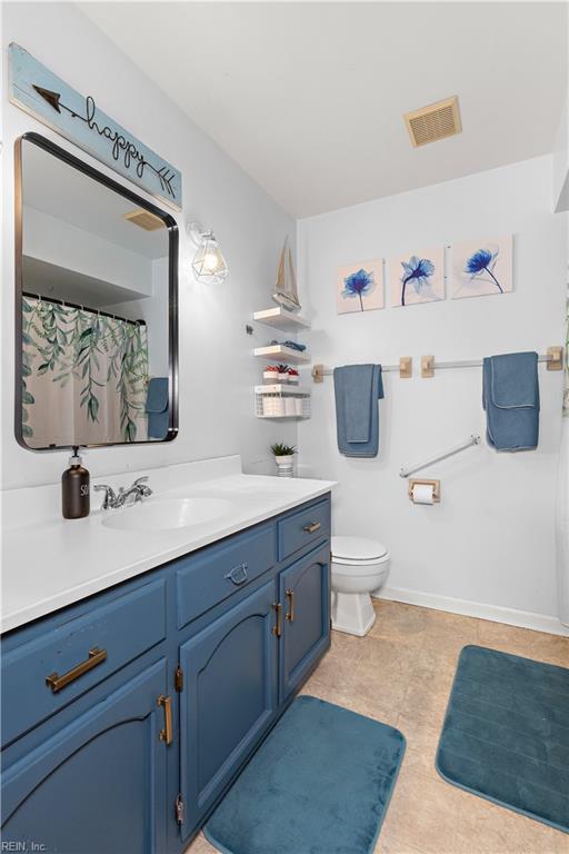 full bath with toilet, baseboards, visible vents, and vanity