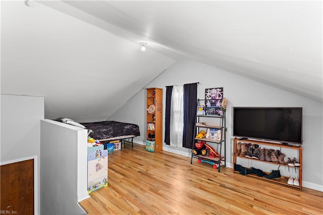 recreation room featuring baseboards, vaulted ceiling, and wood finished floors