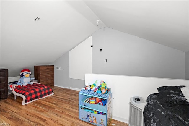 bedroom featuring lofted ceiling, baseboards, and light wood finished floors