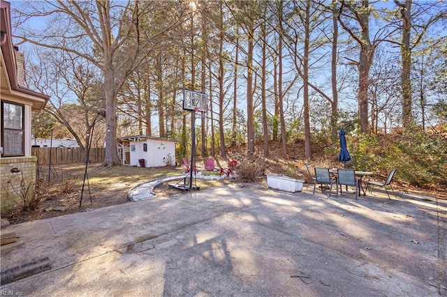 view of patio / terrace with an outbuilding and fence