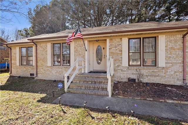 view of front of property with crawl space and brick siding