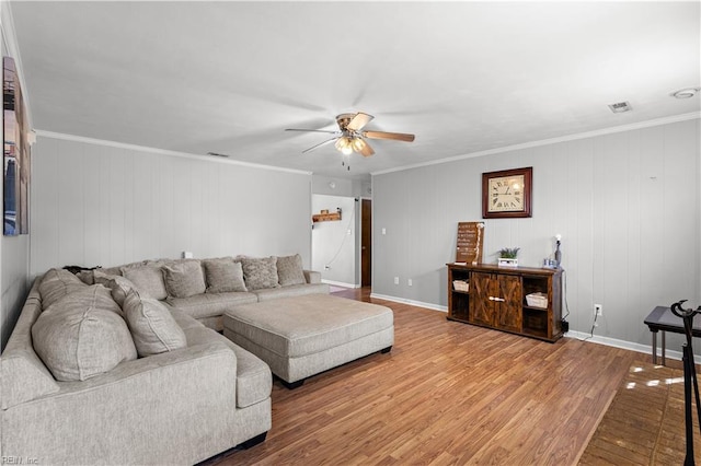 living area with ceiling fan, visible vents, wood finished floors, and ornamental molding