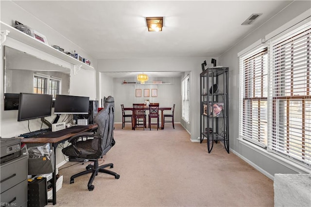 office space featuring baseboards, plenty of natural light, visible vents, and light colored carpet