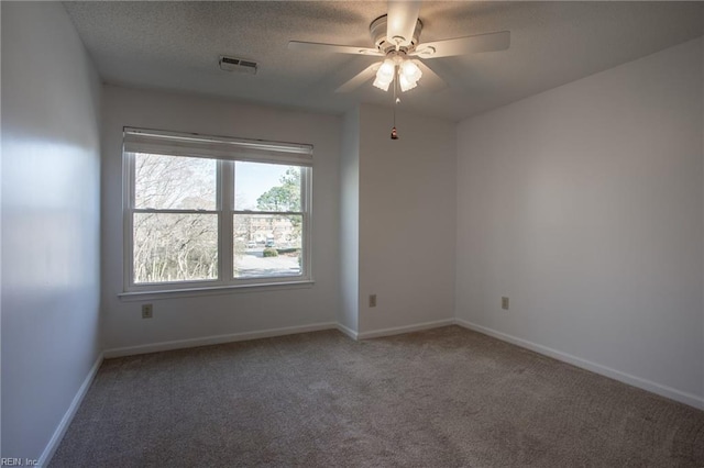 carpeted empty room featuring baseboards, visible vents, ceiling fan, and a textured ceiling