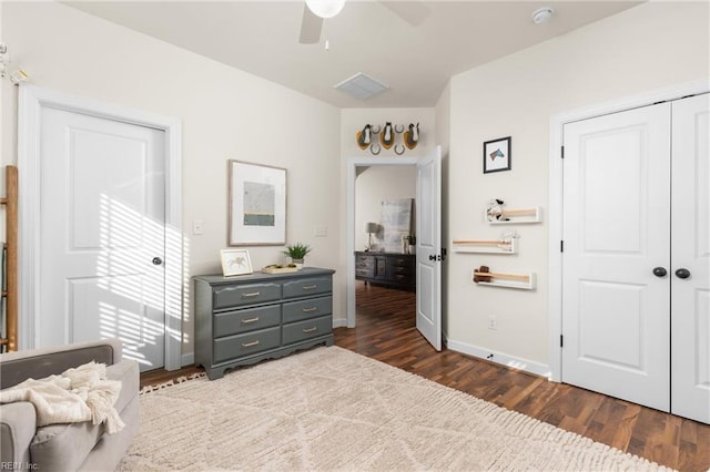 bedroom with dark wood-style floors, a closet, ceiling fan, and baseboards