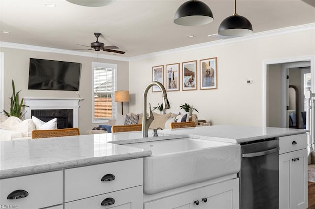 kitchen featuring white cabinets, ornamental molding, open floor plan, stainless steel dishwasher, and a sink