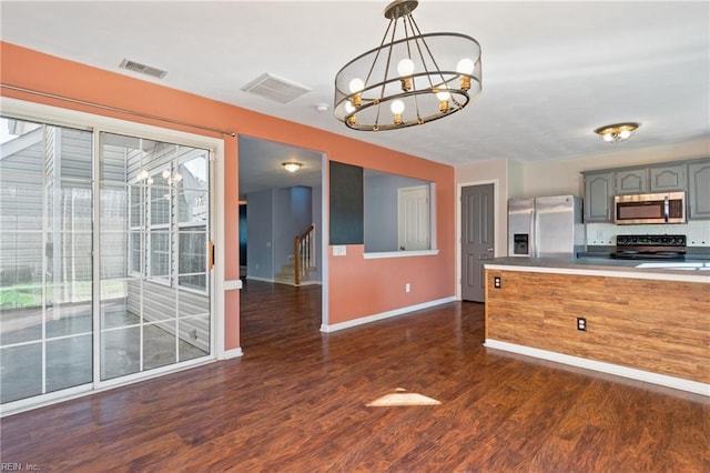 kitchen with stainless steel appliances, visible vents, hanging light fixtures, gray cabinetry, and a chandelier