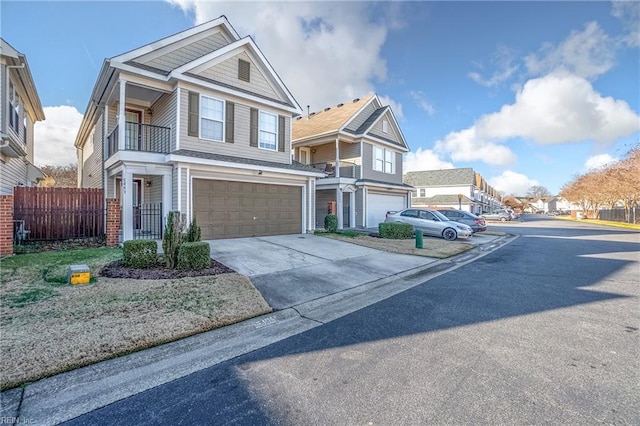 view of front of house with an attached garage, a residential view, fence, and concrete driveway