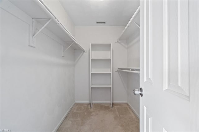 walk in closet featuring light colored carpet and visible vents