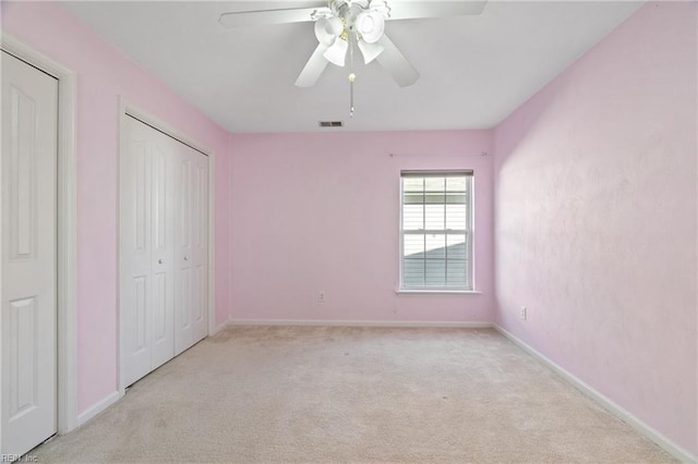 unfurnished bedroom featuring ceiling fan, visible vents, baseboards, and light colored carpet