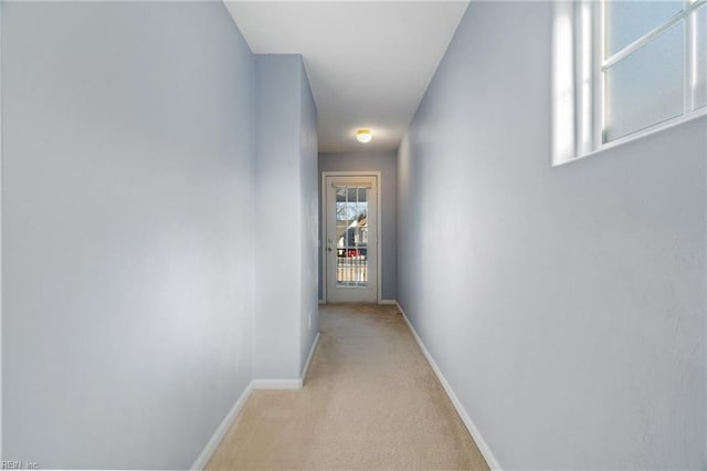 corridor featuring light carpet and baseboards