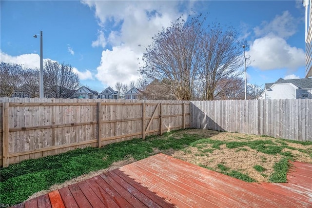 wooden terrace featuring a fenced backyard