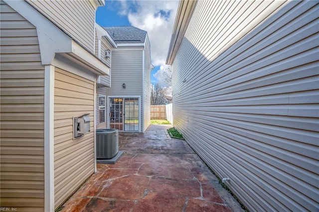 view of home's exterior featuring central AC unit, a patio area, and fence