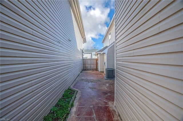 view of side of property with central AC, a patio area, and fence