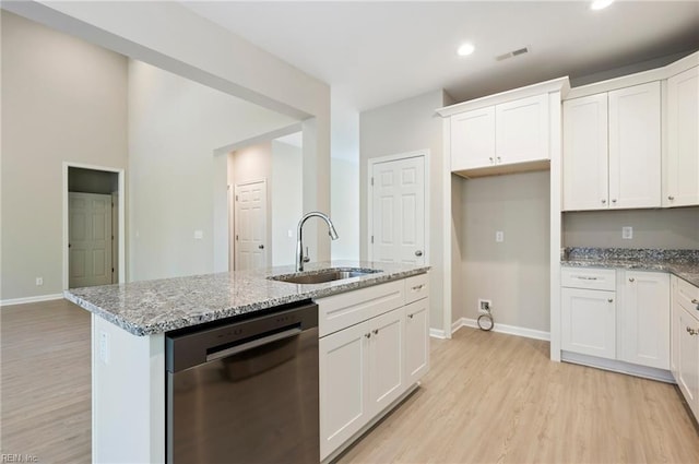 kitchen with visible vents, light stone counters, light wood-type flooring, stainless steel dishwasher, and a sink