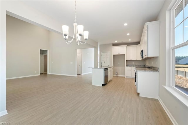 kitchen with a chandelier, light wood-style flooring, white cabinets, open floor plan, and appliances with stainless steel finishes