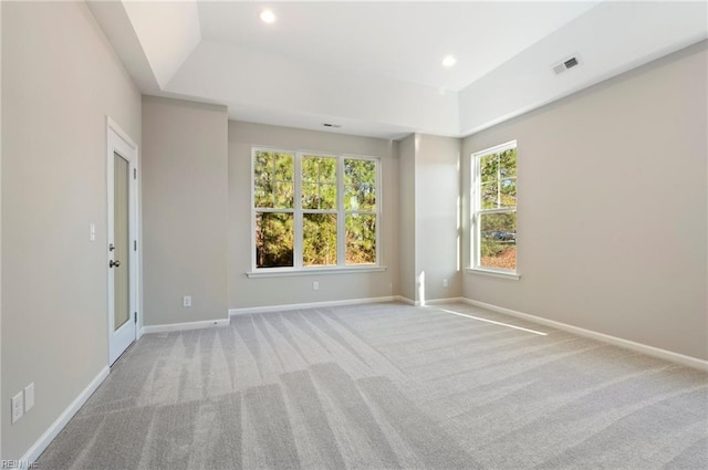 unfurnished room with carpet floors, a tray ceiling, recessed lighting, visible vents, and baseboards