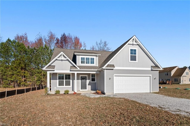 view of front of home with a garage, driveway, roof with shingles, a front lawn, and board and batten siding