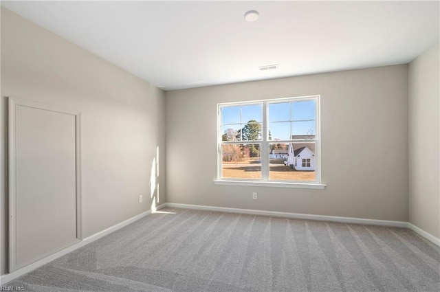 carpeted empty room with visible vents and baseboards