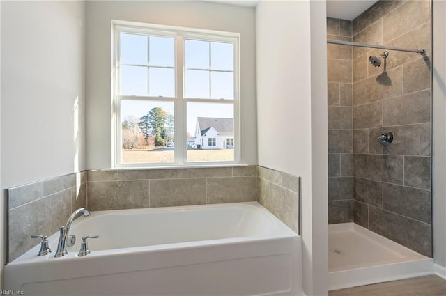 bathroom with a bath and tiled shower