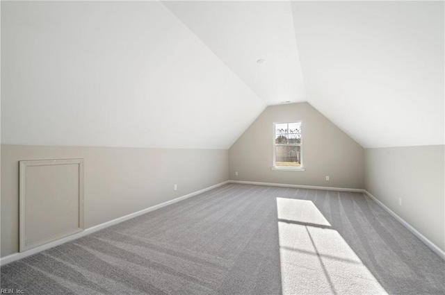 bonus room featuring lofted ceiling, carpet flooring, and baseboards