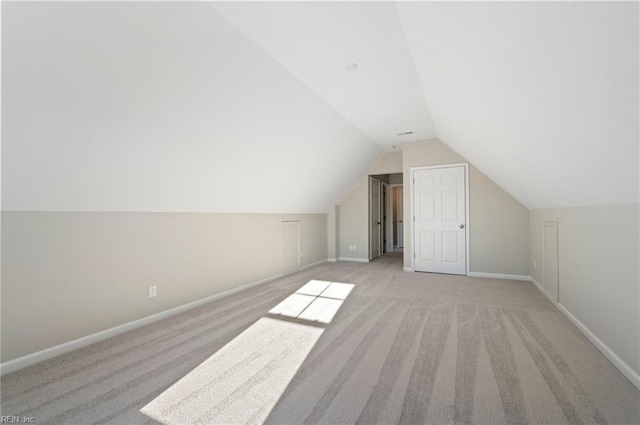 bonus room featuring lofted ceiling, baseboards, and light colored carpet