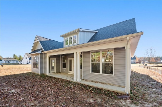 back of house featuring a patio area and a shingled roof